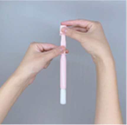 手で郵送検査キットのキャップを外している様子